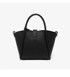 Detailed macro view of black lychee grain leather texture and gold hardware on bucket bag