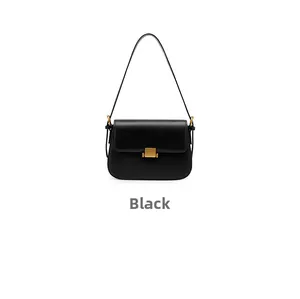Macro shot of minimalist black leather box bag with iconic golden square clasp closure