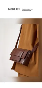 Macro shot of dark brown leather saddle bag detailing geometric layered structure and finish