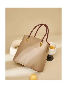 Dettaglio di una borsa a secchiello in pelle con trama a grana e hardware in metallo dorato