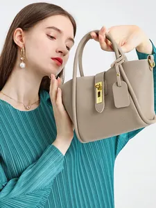 Litchi pattern leather bucket bag with gold hardware shown in a minimalist scene