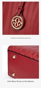 Detail of red leather bag with vintage carved hardware pendant and anti-wear bottom rivets