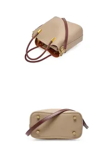 Dettaglio borsa a secchiello in pelle beige con manici rossi e piedini protettivi dorati