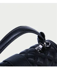 Makro-Detail der echtledernen Stepptasche in Schwarz mit metallischen dunklen Schnallen