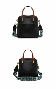 Dettaglio borsa a secchiello in pelle nera con tracolla a righe colorate