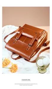 Detailed close-up of a vintage caramel brown leather backpack with strap buckles