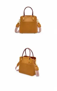 Dettaglio della borsa a secchiello in pelle marrone con grana e tracolla geometrica