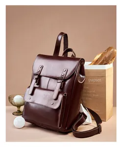 Detail view of large brown leather backpack with retro British style and metal buckles