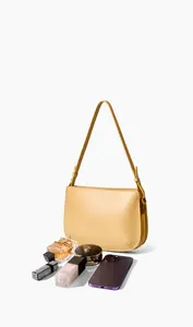 Detail view of yellow leather shoulder bag showing storage capacity for daily essentials