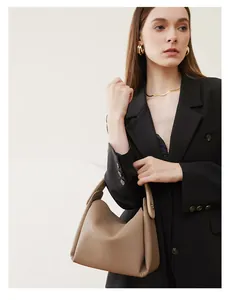 Detail of the brown pebble grain leather bucket bag with minimalist modern styling