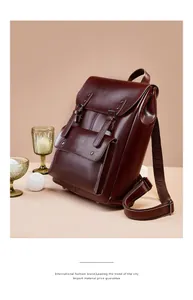 Side view of large brown vintage leather backpack with buckles and adjustable straps