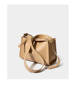 Dettaglio della texture in pelle opaca con fibbia in metallo argentato su borsa marrone