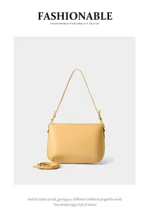 Detail of light yellow leather shoulder bag with fine texture and adjustable strap