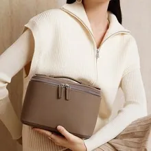 Detail der braunen Lederhandtasche mit Textur, Doppelreißverschluss und robustem Tragegriff