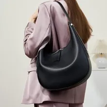Schicke schwarze Hobo-Tasche aus hochwertigem Leder, getragen von einem Model