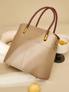 Elegante borsa a secchiello in vera pelle marrone con manici rosso vino e dettagli dorati