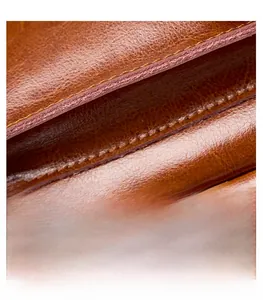 Detailed close-up of high-quality brown leather stitching and vintage pebble texture