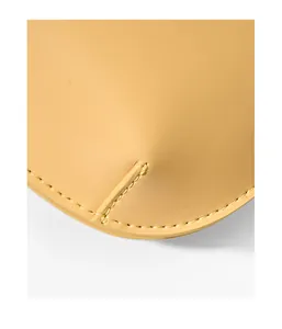 Macro detail of high-quality stitching on a bright yellow leather shoulder bag