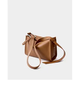 Vista laterale di borsa in pelle marrone con anello metallico argento e trama liscia fine