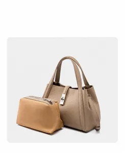 Detail view of khaki leather tote bag featuring a detachable canvas inner pouch and turn-lock