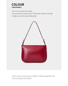 Detailed view of dark red leather shoulder bag showing smooth texture and metal hardware