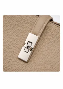 Close-up of golden metal twist lock on khaki pebble grain leather tote bag