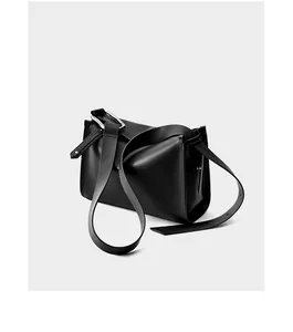 Dettaglio della borsa a tracolla in pelle nera minimalista con anello in metallo argento