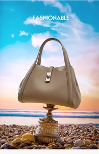 Macro shot of beige lychee texture leather handbag with central metal swivel lock
