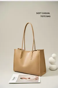 Detalle de bolso tote de cuero caqui con textura suave y correas de hombro finas