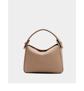 Close-up of premium beige lychee pattern leather and fine rivet details on the handbag