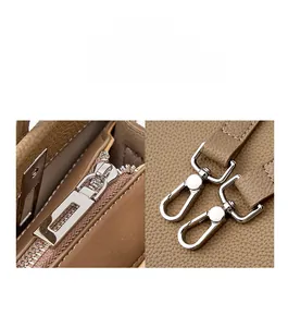 Detail hochwertiger silberner Beschläge auf braunem Leder mit Lychee-Maserung und Zipper