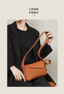 Détail du sac à bandoulière en cuir caramel avec large sangle et texture grainée