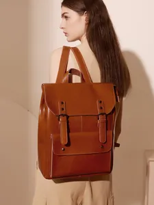 Retro brown leather backpack with large capacity and buckle flap shown from a side view