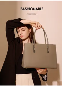Detail einer minimalistischen, tonfarbenen Tragetasche mit Lychee-Textur am Model