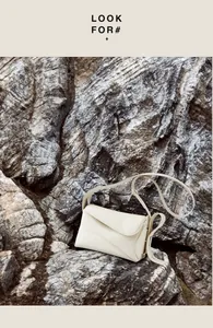 Détail du sac bandoulière en cuir grainé blanc cassé avec rabat incurvé asymétrique