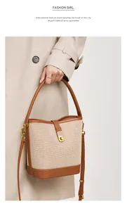 Detail of woven canvas bucket bag with brown leather trim and gold metal closure