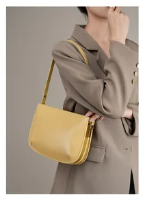 Detail of ginger leather underarm bag featuring vintage gold hardware and premium stitching