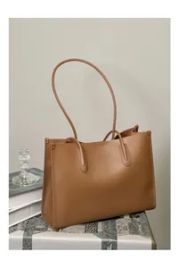 Detalle de bolso tote de cuero marrón que muestra textura y costuras de alta calidad