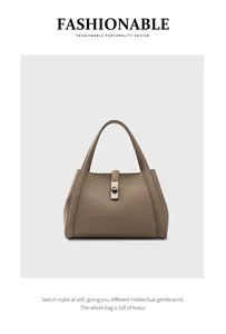 Close-up of pebble grain leather texture and silver lock on a taupe tote handbag