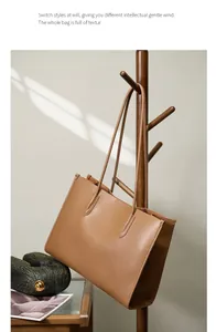 Primer plano del bolso tote de cuero caramelo con correas largas en una percha de madera