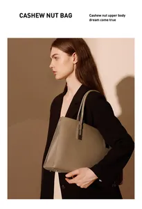 Nahaufnahme der taupefarbenen Ledertasche mit Litschi-Struktur und Silberbeschlägen