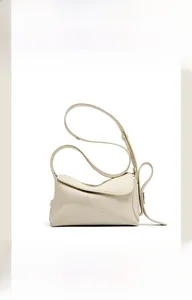 Détail du cuir grainé beige avec surpiqûres géométriques sur le sac à bandoulière