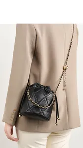 Detail der schwarzen gesteppten Leder-Beuteltasche mit Goldkette und Metallkugel-Deko