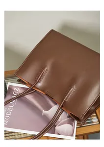 Primer plano de bolso tote de cuero marrón con costuras reforzadas y textura suave