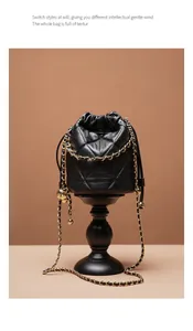 Detailansicht der schwarzen gesteppten Lederbeuteltasche mit goldener Kette und Kordelzug
