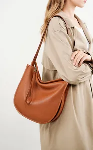 Brown leather tote bag shown on a beige trench coat for a minimalist commuting style