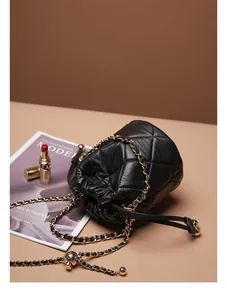 Detailansicht der schwarzen gesteppten Beuteltasche mit Goldkette und Verstellkugel