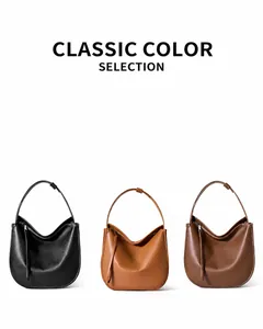 Three minimalist leather crescent shoulder bags in black, caramel brown, and coffee brown