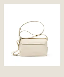 Détail de la texture cuir grainé crème et coutures fines au dos de ce sac à bandoulière