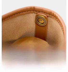 Macro detail of high-quality leather bucket bag with bronze magnetic snap and fine stitching